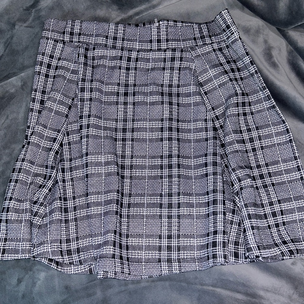 Black/white pleated skirt with elastic waist and zipper.Size L.No stains/tears.